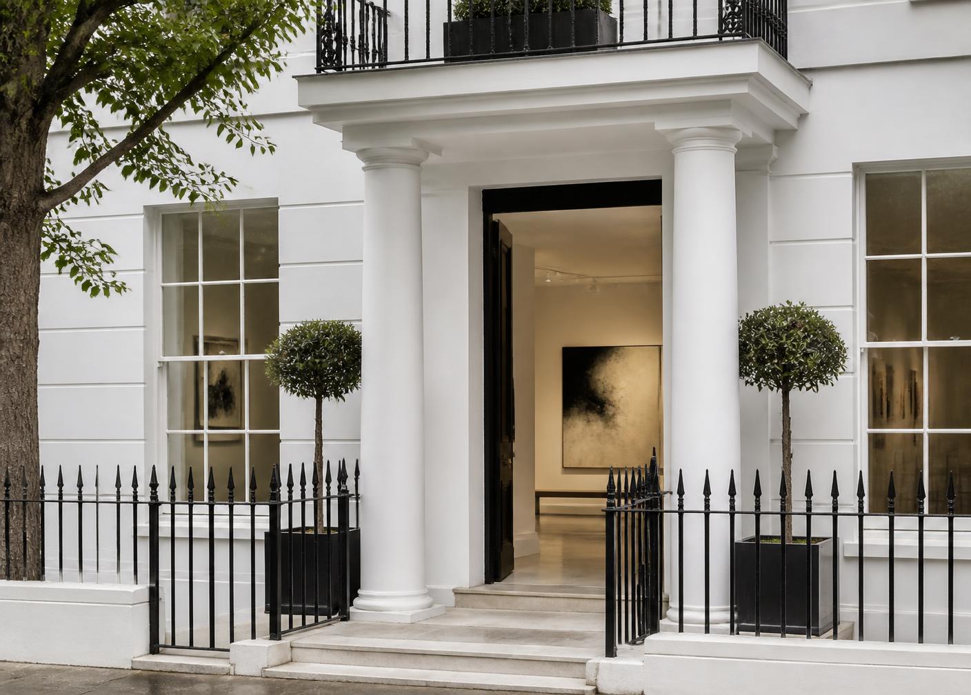 White stucco London townhouse gallery entrance with black iron railings